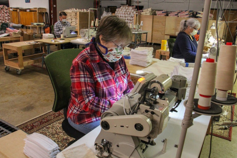 Luanne Albertson (center) sews masks at Eric and Christopher, LLC in Perkasie, Pa. (Emma Lee/WHYY)