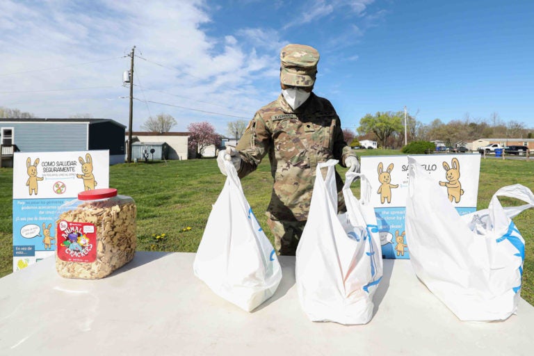 Delaware National Guard Private Kyeremen sets up a station for packaged food pick-up on Wednesday, April 8, 2020, at Frederick Lodge Manufactured Home Community in Townsend, Del. (Saquan Stimpson for WHYY)