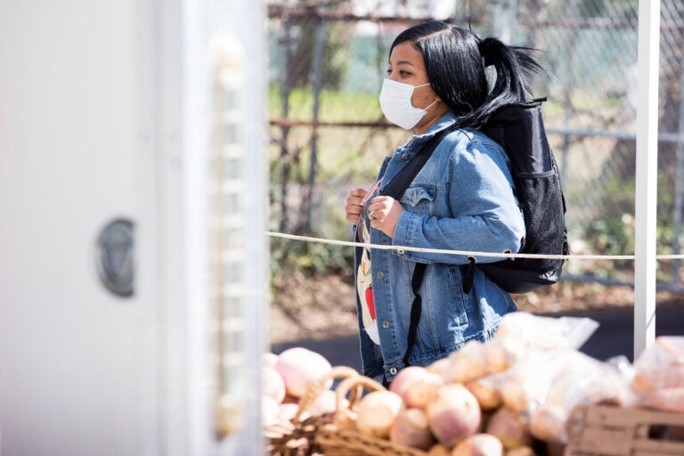 Njeri Harris shops for produce at the Landisdale Farm stand at Clark Park on April 11, 2020. Harris says that the lines enforcing social distancing are 