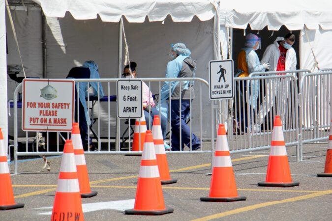 Medical personnel screen COVID-19 testing candidates at a site set up in the Motor Vehicle Commission parking lot in Camden, New Jersey. (Emma Lee/WHYY)