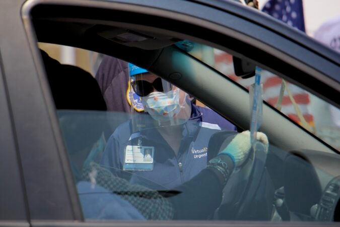 Nurse Practitioner Dodi Iannoco interviews drive-up testing candidates as they arrive at the testing site at 2600 Mt. Ephraim Ave. in Camden, New Jersey. (Emma Lee/WHYY)