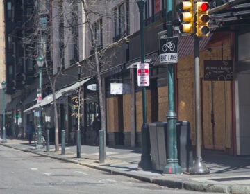 Businesses on Walnut Street in Center City Philadelphia are boarded up during non-essential business shutdown orders aimed to slow the spread of COVID-19. (Kimberly Paynter/WHYY)