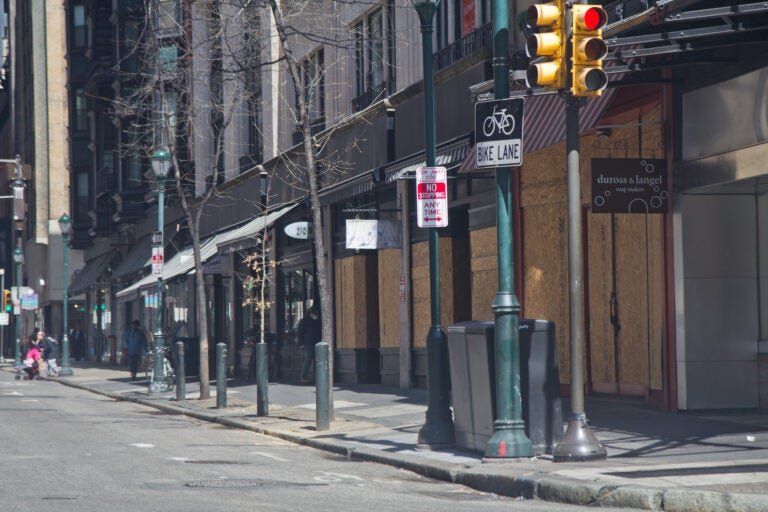 Businesses on Walnut Street in Center City Philadelphia are boarded up during non-essential business shutdown orders aimed to slow the spread of COVID-19. (Kimberly Paynter/WHYY)