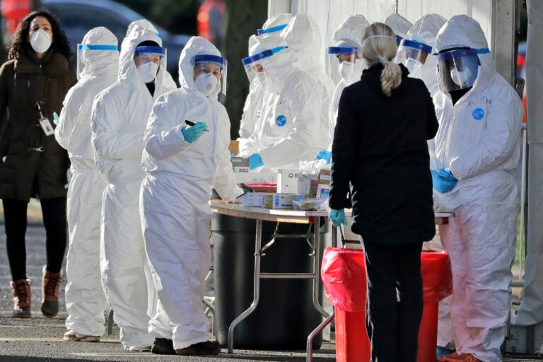 Staff in protective equipment prepare to test people at a drive-thru COVID-19 testing site at the PNC Bank Arts Center in Holmdel, N.J.