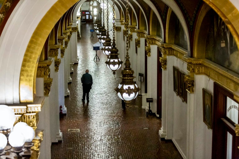 House of Representatives security officer Seamus Smith walks the hall after the morning session on Tuesday, March 24, 2020 in Harrisburg, Pa. (Joe Hermitt/The Patriot-News via AP)