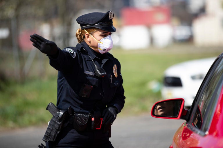 Camden County Police Officer Rodriguez wears a protective mask as she directs people to a COVID-19 testing facility in Camden, N.J., Wednesday, April 1, 2020. .(Matt Rourke/AP Photo)