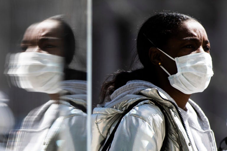 A person wearing protective masks due to coronavirus concerns walks in Philadelphia, Thursday, April 2, 2020. (AP Photo/Matt Rourke)