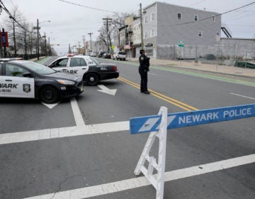 A police officer stands at an intersection on the border between Irvington and Newark, N.J., Friday, April 3, 2020. (Seth Wenig/AP Photo)