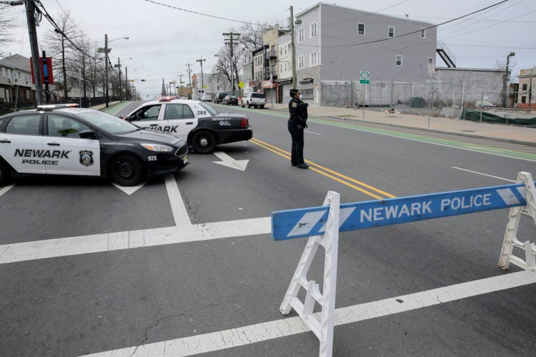A police officer stands at an intersection on the border between Irvington and Newark, N.J., Friday, April 3, 2020. (Seth Wenig/AP Photo)