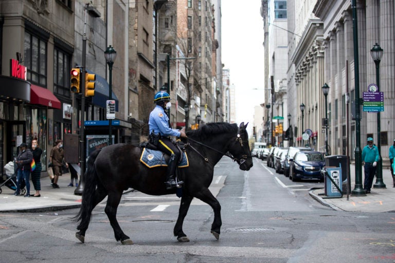 A mounted officer patrols while wearing a face mask to protect against the spread of new coronavirus, in Philadelphia, Wednesday, April 8, 2020. (AP Photo/Matt Rourke)