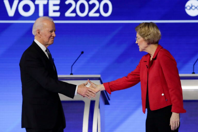 FILE- In this Feb. 7, 2020 file photo, Democratic presidential candidates former Vice President Joe Biden, and Sen. Elizabeth Warren, D-Mass., shake hands on stage before the start of a Democratic presidential primary debate hosted by ABC News, Apple News, and WMUR-TV at Saint Anselm College in Manchester, N.H. Warren has endorsed Joe Biden, becoming the last of the former vice president’s major Democratic presidential rivals to formally back him.(AP Photo/Charles Krupa)