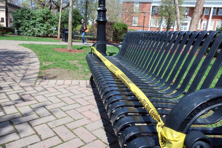 Police tape covers park benches in Rutherford, New Jersey, to enforce social distancing during the coronavirus pandemic on Sunday, April 19, 2020. (AP Photo/Ted Shaffrey)