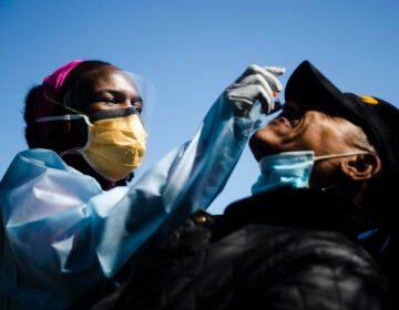 Dr. Ala Stanford administers a COVID-19 swab test on Wade Jeffries in the parking lot of Pinn Memorial Baptist Church in Philadelphia, Wednesday, April 22, 2020. (AP Photo/Matt Rourke)