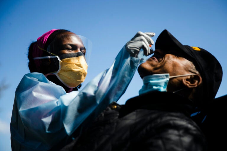 Dr. Ala Stanford administers a COVID-19 swab test on Wade Jeffries in the parking lot of Pinn Memorial Baptist Church in Philadelphia, Wednesday, April 22, 2020. (AP Photo/Matt Rourke)