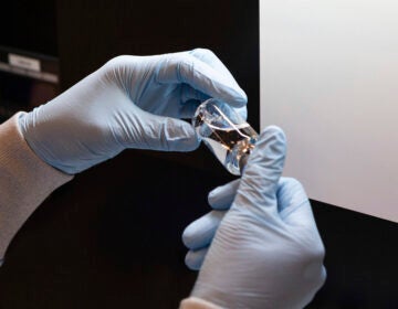 In this March 2020 photo provided by Gilead Sciences, a vial of the investigational drug remdesivir is visually inspected at a Gilead manufacturing site in the United States. (Gilead Sciences via AP)