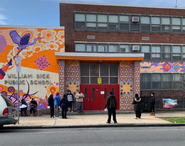 People outside William Dick Elementary School in North Philadelphia wait to pick up Chromebooks.