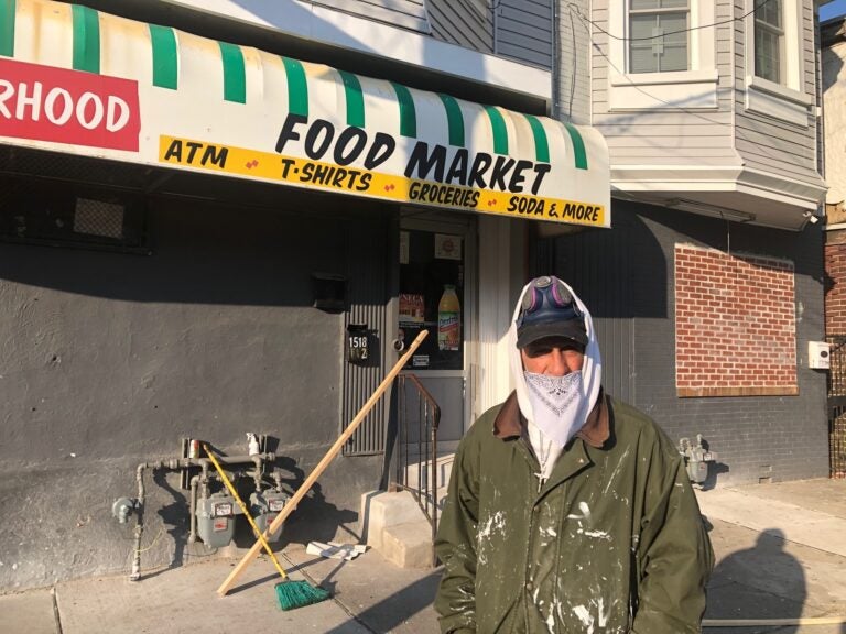 Melvin Santiago wear his makeshift mask Friday morning while doing some renovation and repair work at a store on Fourth Street and Delamore Place in Wilmington. (Cris Barrish/WHYY)