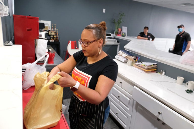 Johanny Cepeda-Freytiz bags up food that was ordered ahead of time for pick up on April 3, 2020, at Mi Casa Su Casa cafe in Reading, Pennsylvania. (Matt Smith for Keystone Crossroads)