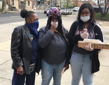 Neya Foster (right) with a new laptop and her mother and older sister were at Sayre High in West Philadelphia. (Bill Hangley/The Notebook)