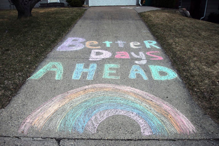 A chalk message and rainbow adorn a driveway with a positive message in the fight against the coronavirus at a home on Wednesday, April 1, 2020. (AP Photo/Jim Mone)