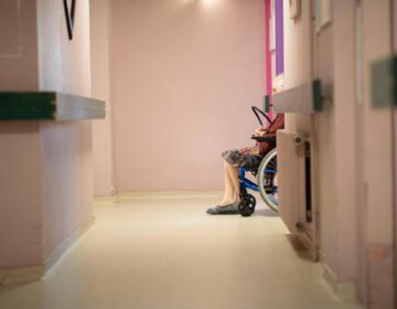 A resident is pictured using a wheelchair inside a nursing home.