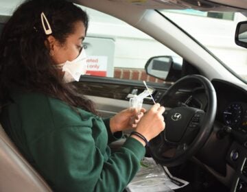 A driver opens a self-testing kit at a CVS drive-through. (Provided by CVS Health)