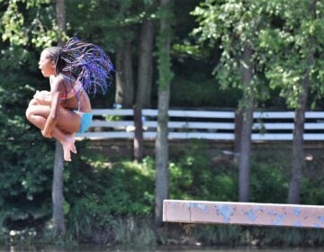 Summer camper leaps off a diving platform