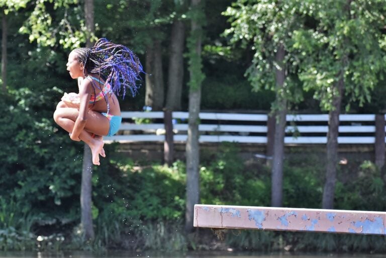 Summer camper leaps off a diving platform