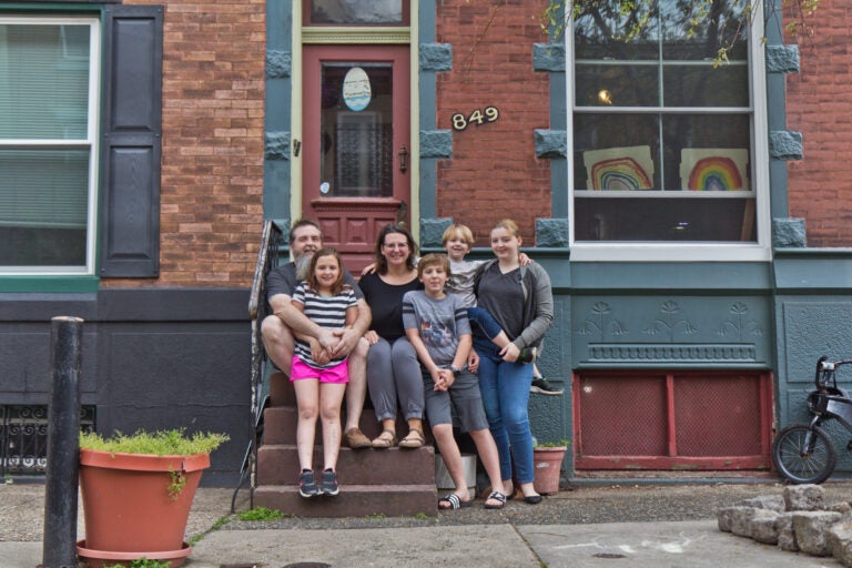 Wayne and Andrea Clark with their children Molly, 9, Caleb, 11, Roisin, 13, and Cianan, 6, on the steps of their home in Philadelphia. (Kimberly Paynter/WHYY)