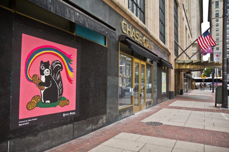 The Mural Arts Program installed works on storefronts boarded up due to coronavirus lockdowns in Center City. This cheerful squirrel across from City Hall is by artist Gina Triplett. (Kimberly Paynter/WHYY)