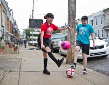 Yvanna, 13, (right), and Emilia, 12, (left) play with soccer balls on their block. (Kimberly Paynter/WHYY)