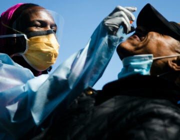 Dr. Ala Stanford administers a COVID-19 swab test on Wade Jeffries in the parking lot of Pinn Memorial Baptist Church in Philadelphia, Wednesday, April 22, 2020. Stanford and other doctors formed the Black Doctors COVID-19 Consortium to offer testing and help address heath disparities in the African American community. (AP Photo/Matt Rourke)