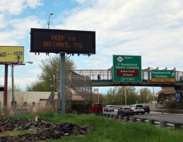 A sign reminds people to social distance during the coronavirus pandemic in Secaucus, New Jersey, on Monday, May 4, 2020. (AP Photo/Ted Shaffrey)