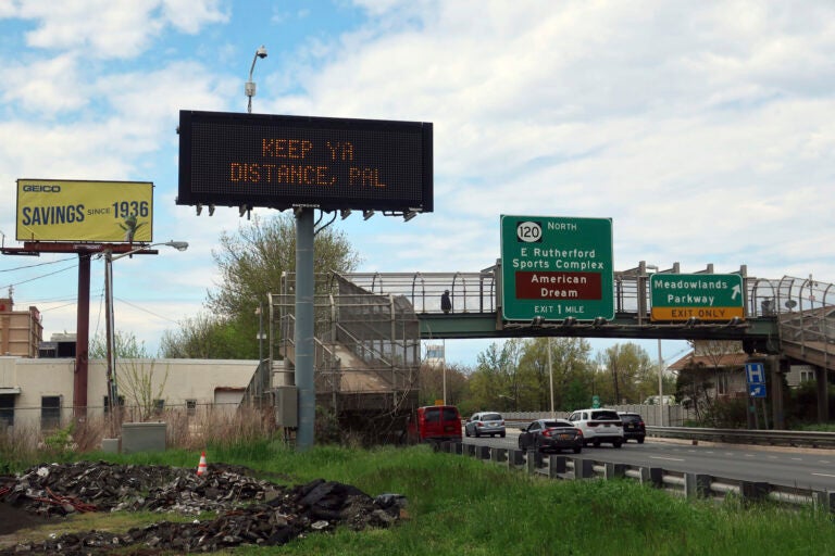 A sign reminds people to social distance during the coronavirus pandemic in Secaucus, New Jersey, on Monday, May 4, 2020. (AP Photo/Ted Shaffrey)