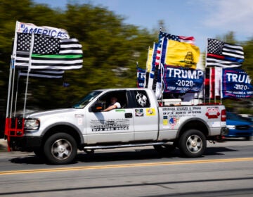 A man drives a truck decorated with flags ahead of President Donald Trump's scheduled visit at Owens and Minor warehouse in Allentown, Pa., Thursday, May 14, 2020. (AP Photo/Matt Rourke)