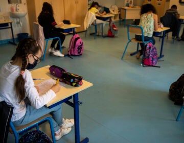 Students, wearing face masks and paying attention to social distancing, study at Les Magnolias primary school during the partial lifting of coronavirus, COVID-19, lockdown regulations in Brussels, Monday, May 18, 2020. (AP Photo/Francisco Seco)