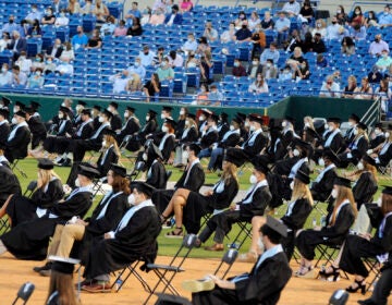 Senior class members and spectators, most of them wearing masks, attend the graduation ceremony of Spain Park High School in Hoover, Ala., Wednesday, May 20, 2020. Health officials say usual graduation ceremonies could endanger the public health by promoting the spread of disease. But school officials say they're using social distancing guidelines and abiding by state health rules. (AP Photo/Jay Reeves)