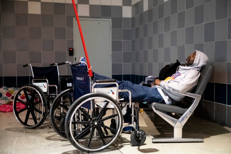 A homeless person sleeps at Philadelphia International Airport in Philadelphia, Monday, May 25, 2020. (AP Photo/Matt Rourke)