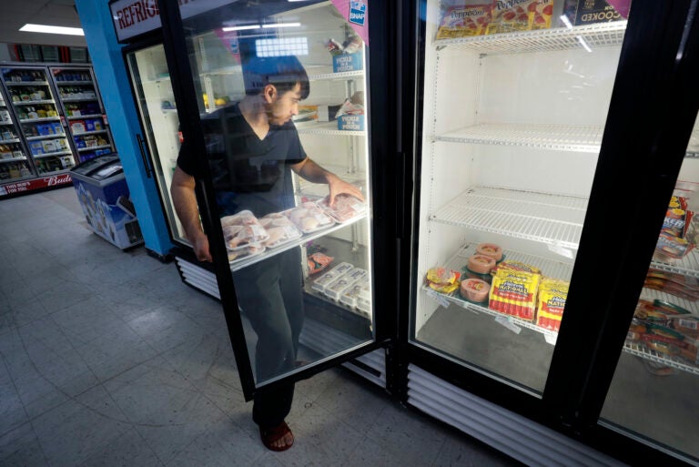Hardik Kalra stocks meat in a cooler at a local super market, Friday, May 29, 2020, in Des Moines, Iowa. (AP Photo/Charlie Neibergall)