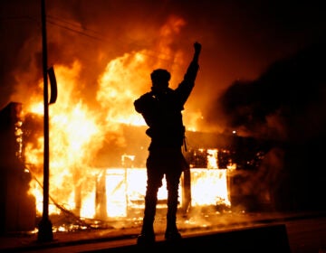 In this May 29, 2020, photo, a check-cashing business burns during protests in Minneapolis. (AP Photo/John Minchillo)