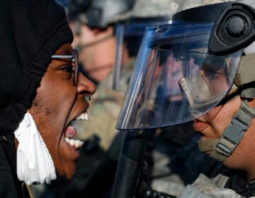 Protesters and National Guardsmen face off on East Lake Street, Friday, May 29, 2020, in St. Paul, Minn. (AP Photo/John Minchillo)