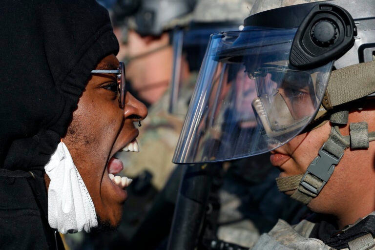 Protesters and National Guardsmen face off on East Lake Street, Friday, May 29, 2020, in St. Paul, Minn. (AP Photo/John Minchillo)