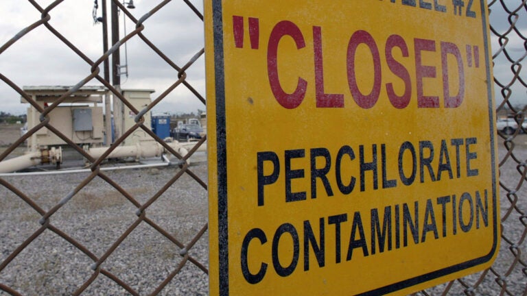 A sign posted outside a water well indicates perchlorate contamination