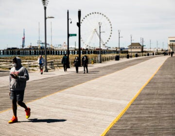 Person wears mask while walking Atlantic City boardwalk