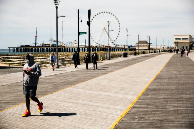 Person wears mask while walking Atlantic City boardwalk