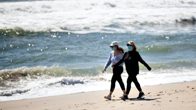 People wear protective face masks on NJ beach