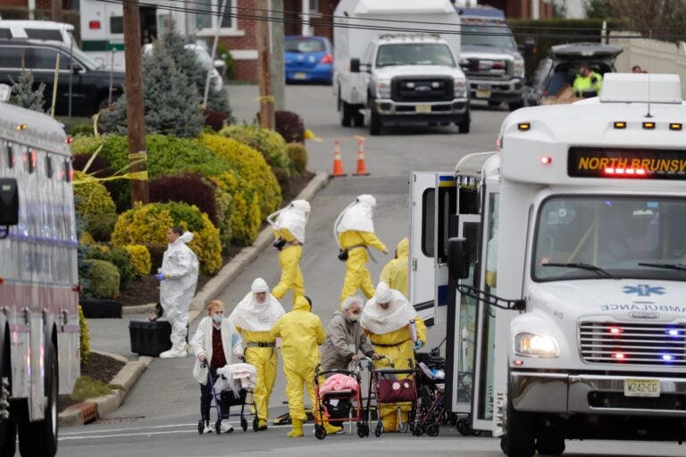 Residents from St. Joseph's Senior Home are helped on to buses in Woodbridge, N.J., Wednesday, March 25, 2020. (AP Photo/Seth Wenig)