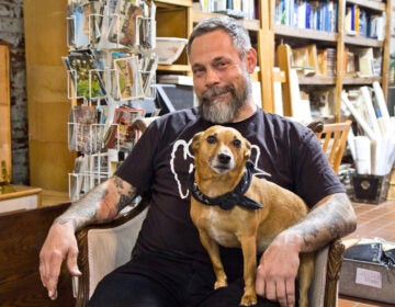 Mike 'Supermodel,' the owner of Jinxed stores, with his dog Ronnie. (Kimberly Paynter/WHYY)