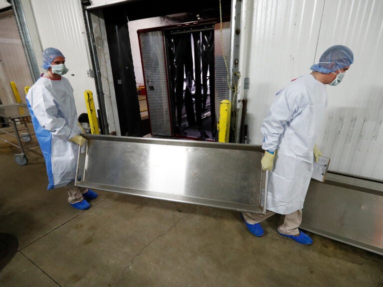 Medical examiners and coroners are the last stop for investigating unexpected deaths, including those who may have died of COVID-19. In April, the Cook County Medical Examiner opened a surge center to handle overflow from Chicago-area hospital morgues. (Charles Rex Arbogast/AP)