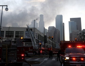 Smoke rises from the scene of a fire and explosion in Los Angeles on Saturday that injured 11 firefighters.